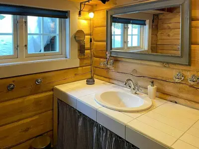 a bathroom with a sink and a mirror at Idyllic Log Cabin At Nordseter in Lillehammer