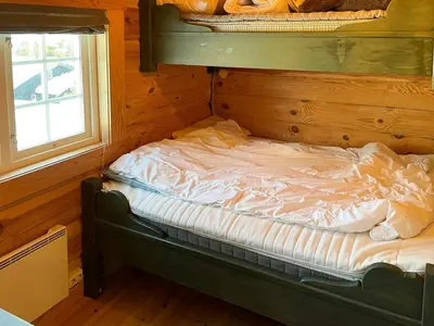 an empty bed in a room with a window at Idyllic Log Cabin At Nordseter in Lillehammer