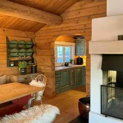 a kitchen in a log cabin with a fireplace at Idyllic Log Cabin At Nordseter in Lillehammer