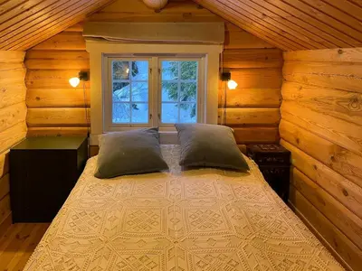 a bedroom with a bed with two pillows and a window at Idyllic Log Cabin At Nordseter in Lillehammer