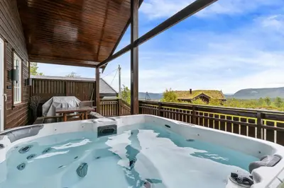 a hot tub on the balcony of a house at Peaceful Cabin With View And Jacuzzi At Blefjell in Kongsberg