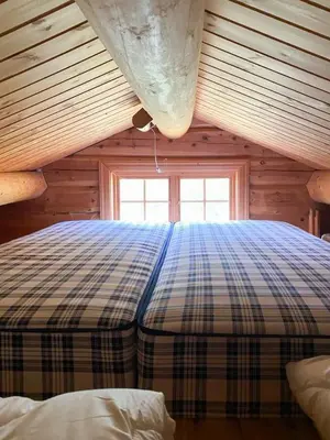 a bedroom with a plaid bed in a cabin at Mountain Cabin By Hundsåvatnet With Large Veranda in Søvassli