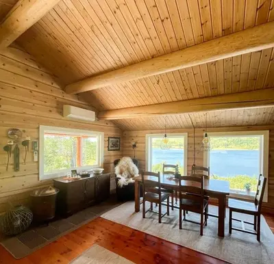a dining room with a wooden ceiling and a table and chairs at Mountain Cabin By Hundsåvatnet With Large Veranda in Søvassli