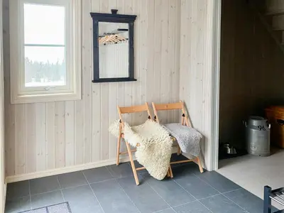 a wooden rocking chair in a room with a window at New Cabin With Mountain View In Bittermark, Trysil in Trysil