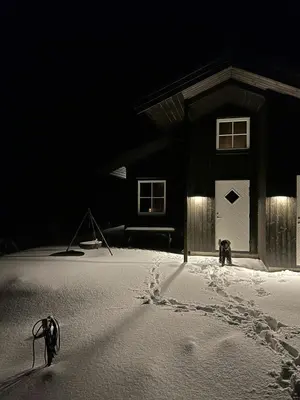 a building with a white door and footprints in the snow at New Cabin With Mountain View In Bittermark, Trysil in Trysil