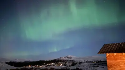 a view of a city from a house in the snow at Architect-Designed Cabin By Rondane in Høvringen