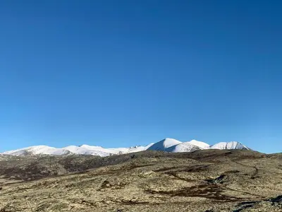 a mountain range with snow covered mountains in the background at Architect-Designed Cabin By Rondane in Høvringen