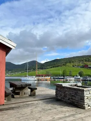 a dock with a bench and boats in the water at Charming & Modern Seaside House In Valsøyfjord in Valsøyfjord