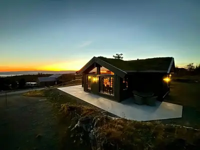 a small house with a roof on a lot at Architect Mountain Cabin At Lygna With Views in Jaren
