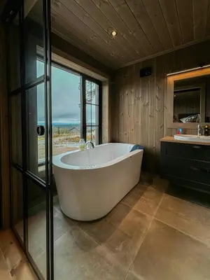 a large bath tub in a bathroom with a window at Architect Mountain Cabin At Lygna With Views in Jaren