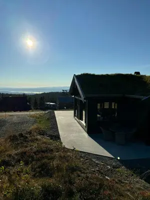 a house with a roof with the sun in the sky at Architect Mountain Cabin At Lygna With Views in Jaren