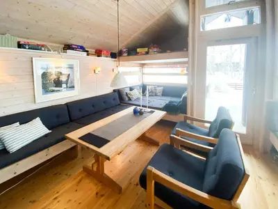 a living room with a blue couch and a wooden table at Modern Mountain Cabin Near Hiking Terrain in Geilo