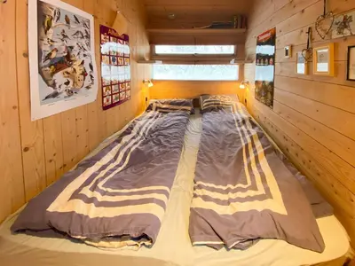 a large bed in a room with wooden walls at Modern Mountain Cabin Near Hiking Terrain in Geilo