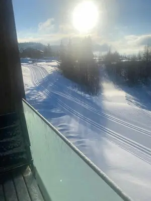 a snow covered road with the sun in the background at Lovely, New Apartment At Kvitfjell With Ski-In Out in Fåvang