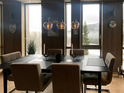 a dining room with a black table and chairs at Lovely, New Apartment At Kvitfjell With Ski-In Out in Fåvang