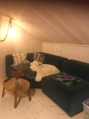 a living room with a couch and a table at Fantastic Forest Cabin With Panoramic View in Jaren