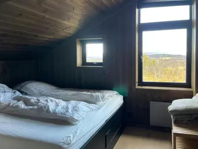 a small bedroom with two beds and two windows at Spacious Mountain Cabin With Fantastic Views in Ål