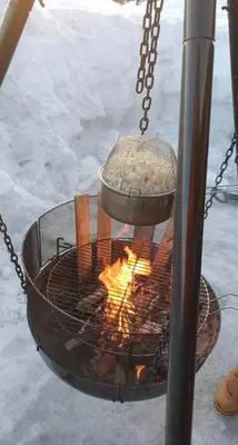 a fire grill with a bowl of food over it at Cozy Ambiance And Trails At Skeikampen in Svingvoll