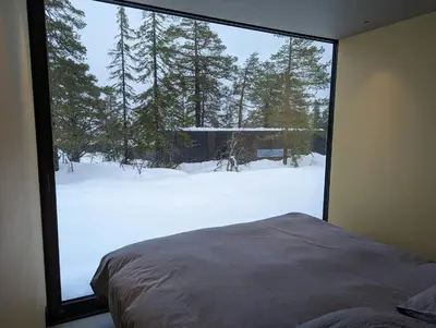 a bedroom window with a view of a snow covered yard at Modern Cabin By Snøhetta At Blefjell in Svene