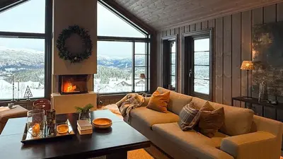 a living room with a couch and a table with a fireplace at Adventure And Relaxation In Voss in Vossevangen