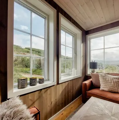 a room with three windows and a chair and a couch at Unique Cabin By The Ski Slope In Hovden in Hovden