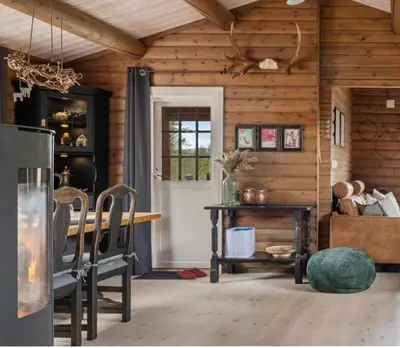 a dining room with a table and a door at Charming Log Cabin With Modern Luxury in Jordet