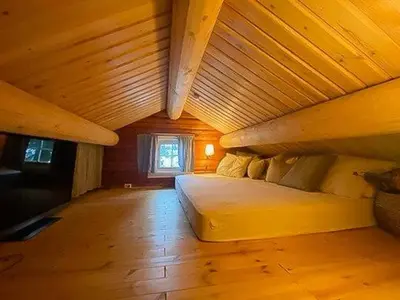 a bed in a room with a wooden ceiling at Log Cabin With Modern Style Near Vardefjell in Etnedal