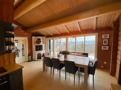 a dining room with a wooden table and chairs at Log Cabin With Modern Style Near Vardefjell in Etnedal