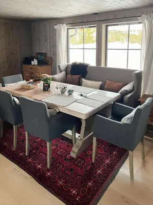 a dining room table with chairs and a couch at Nature-Close Cabin By The Water in Eggedal