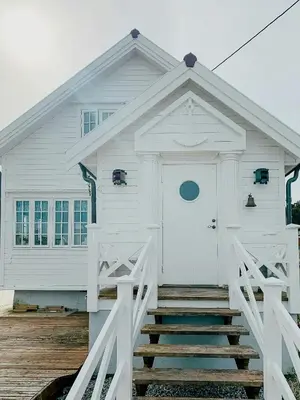 a white house with stairs leading to the front door at Charming Southern Norway Idyll On Trøndelag Coast in Sula
