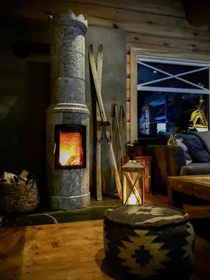 a living room with a stone stove in a room at Rustic Log Cabin At The Foot Of Hardangervidda in Uvdal