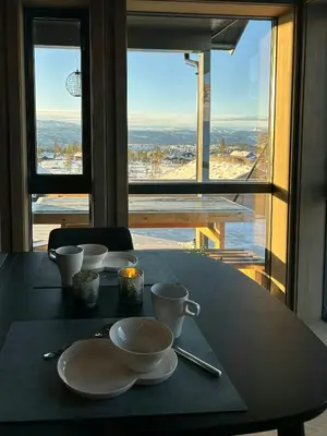 a table with plates and cups on a table with a view at Cabin With Panoramic Views In Turufjell in Flå