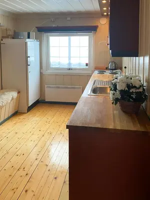 a kitchen with a white refrigerator and a wooden floor at Charming Cabin With Fantastic View In Sjusjøen in Sjusjøen