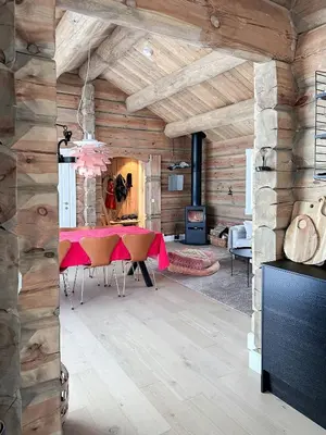 a dining room with a table in a room with wooden walls at Spectacular Cabin With View In Jotunheimen in Eidsbugarden