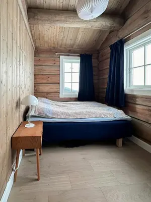 a bedroom with a large bed in a log cabin at Spectacular Cabin With View In Jotunheimen in Eidsbugarden