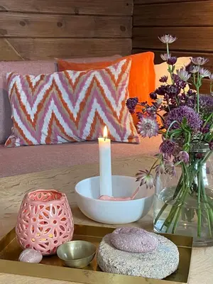 a candle sitting on a table with flowers and vases at Charming Cabin On Veiholmen's Inner Harbor in Smøla