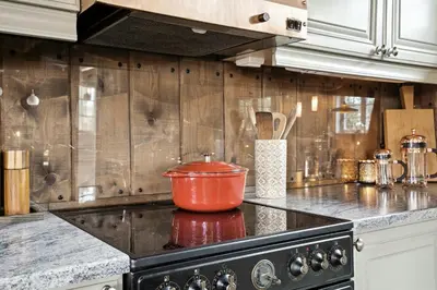 a kitchen counter with an orange pot on the stove at Old Swiss Hotel Charm In Seljestad in Vinjeøra