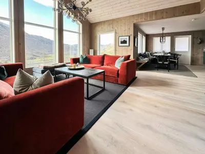 a living room with red couches and a table at Mountain Cabin Near Solheisen In Grøndalen in Hemsedal
