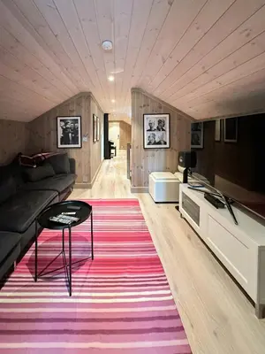 a living room with a couch and a table on a rug at Mountain Cabin Near Solheisen In Grøndalen in Hemsedal