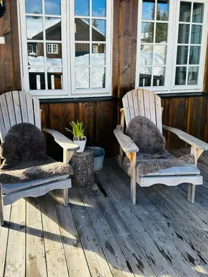 two rocking chairs sitting on a porch with windows at Family Cabin With Ski Inout At Furutangen in Vika