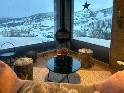 a living room with a couch and a large window at Cabin With Panoramic And Ski Trails Outside in Rauland