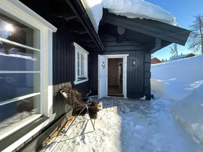 a house with two birds standing outside of a window at Cabin With Panoramic View In Synnfjell in Nord Torpa