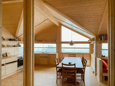 a kitchen and dining room with a table and chairs at Cabin With Award-Winning Design On Norefjell in Eggedal
