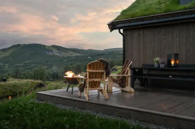 a patio with two chairs and a table on a deck at Unique & Exclusive Mountain Cabin In Geilo in Geilo