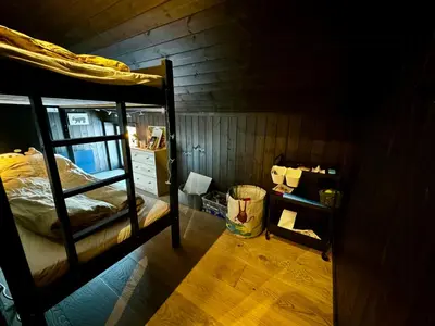 a room with two bunk beds and a wooden wall at Modern Apartment Overlooking Gudbrandsdalen in Øyer