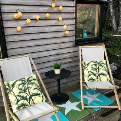 two folding chairs and a table on a patio at Architect Drawn Cabin Between Sea And Mountain in Hosen
