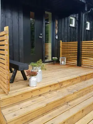 a wooden deck with a bench on a house at Sunny Cabin With Panoramic Views At Sjusjøen in Sjusjøen