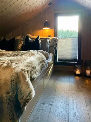 a bedroom with a large bed and a window at Ski Inski Out-Hytte I Hafjell Med Udsigt in Øyer