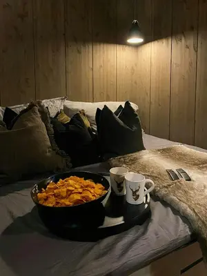 a tray with a bowl of food and two cups on a bed at Ski Inski Out-Hytte I Hafjell Med Udsigt in Øyer