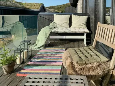 a bench sitting on a deck with a rug at Cosy Apartment With Ski Inout In Hafjell in Øyer